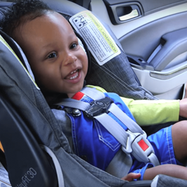 Smiling toddler sitting in car seat